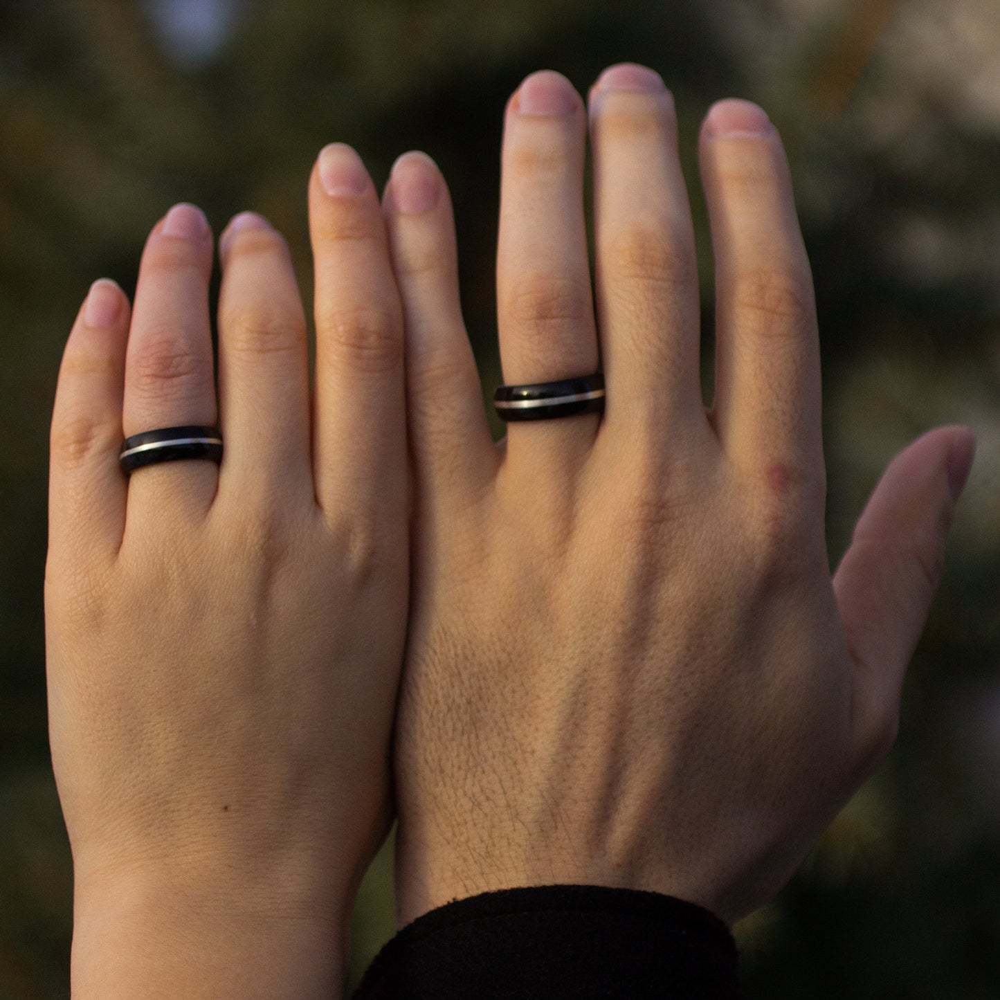 Couple wearing matching Ebony Wood Rings with Silver Inlay by Andrwood, perfect as commitment rings or wood wedding bands.