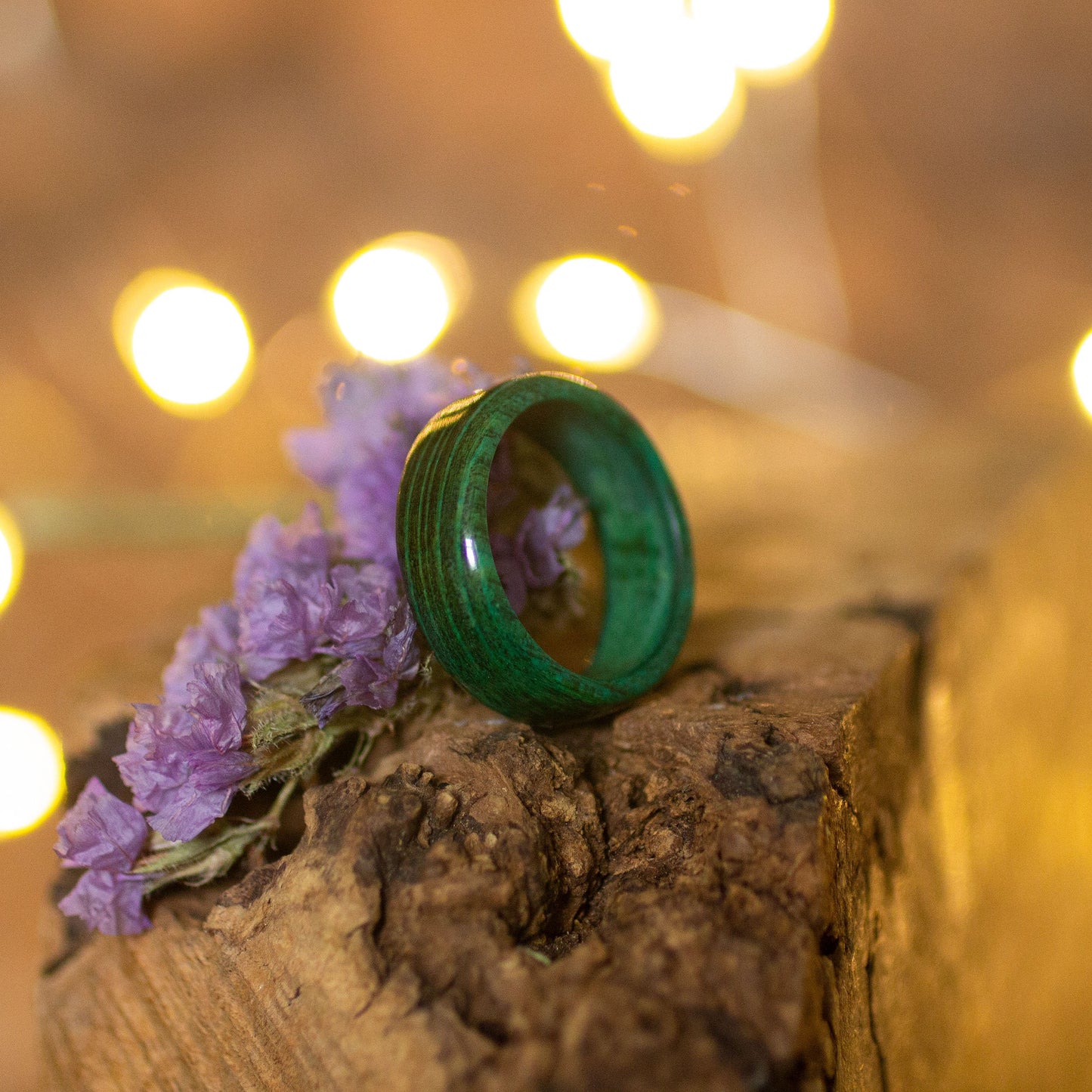 Angled view of green hornbeam wood ring, showing matte finish and hand-shaped curve.