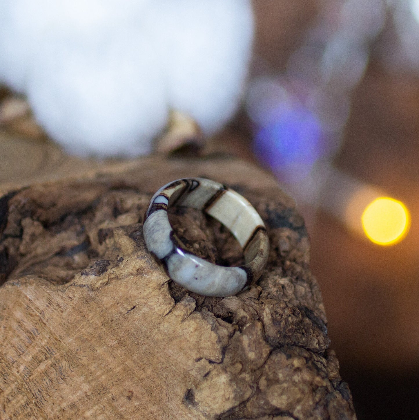 Epoxy birch ring on natural wood, showing contrast between light birch and clear resin.