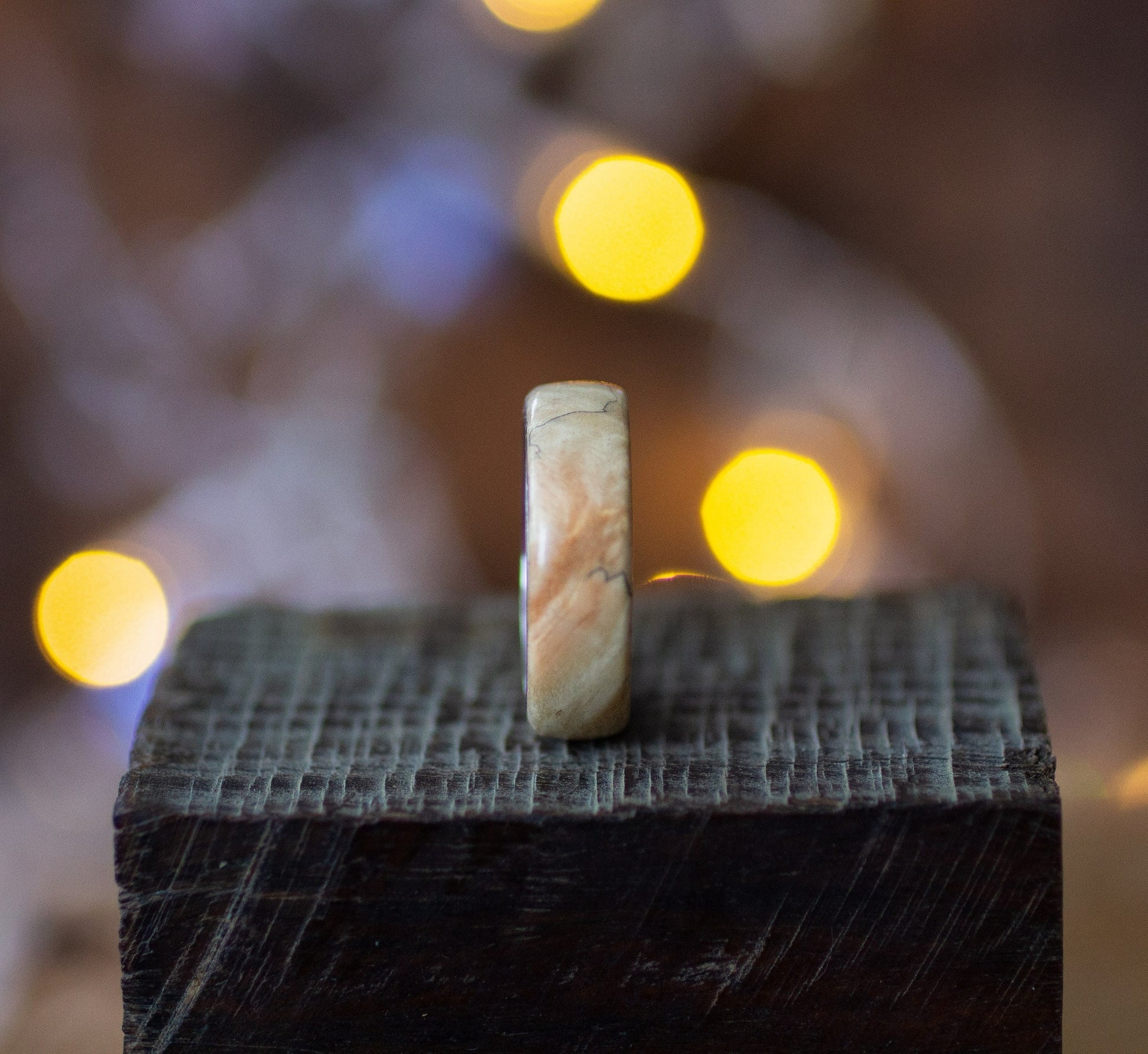 Side view of Maple Wood Ring with Stainless Steel Core by Andrwood, highlighting smooth edges and unique wood grain pattern.