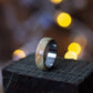 Close-up of Andrwood Maple Wood Ring with Stainless Steel Core on wooden block, emphasizing craftsmanship and minimalist design.