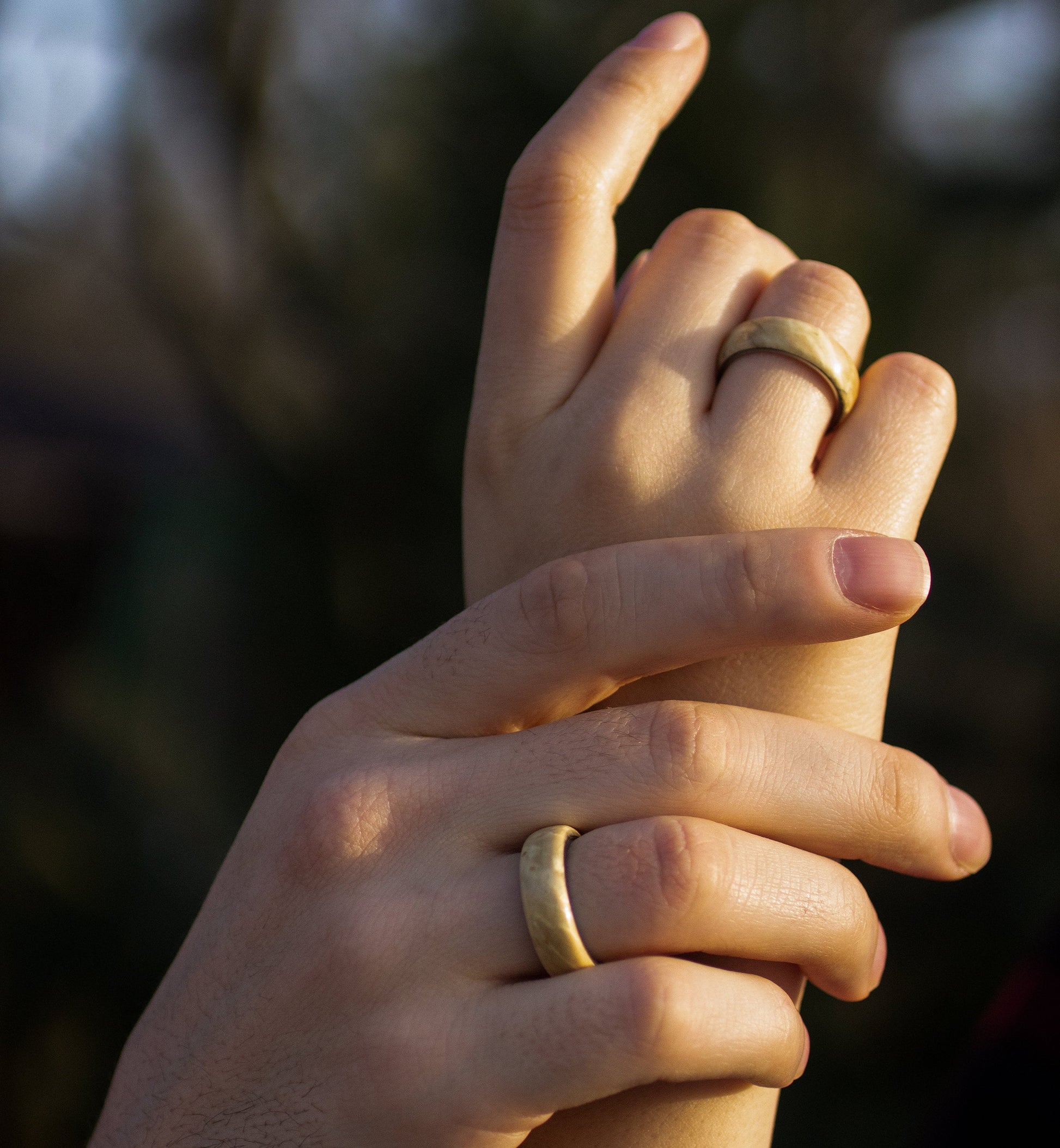 Hands intertwined wearing Maple Wood Rings with Stainless Steel Core by Andrwood, perfect for gay, lesbian, or young couples.