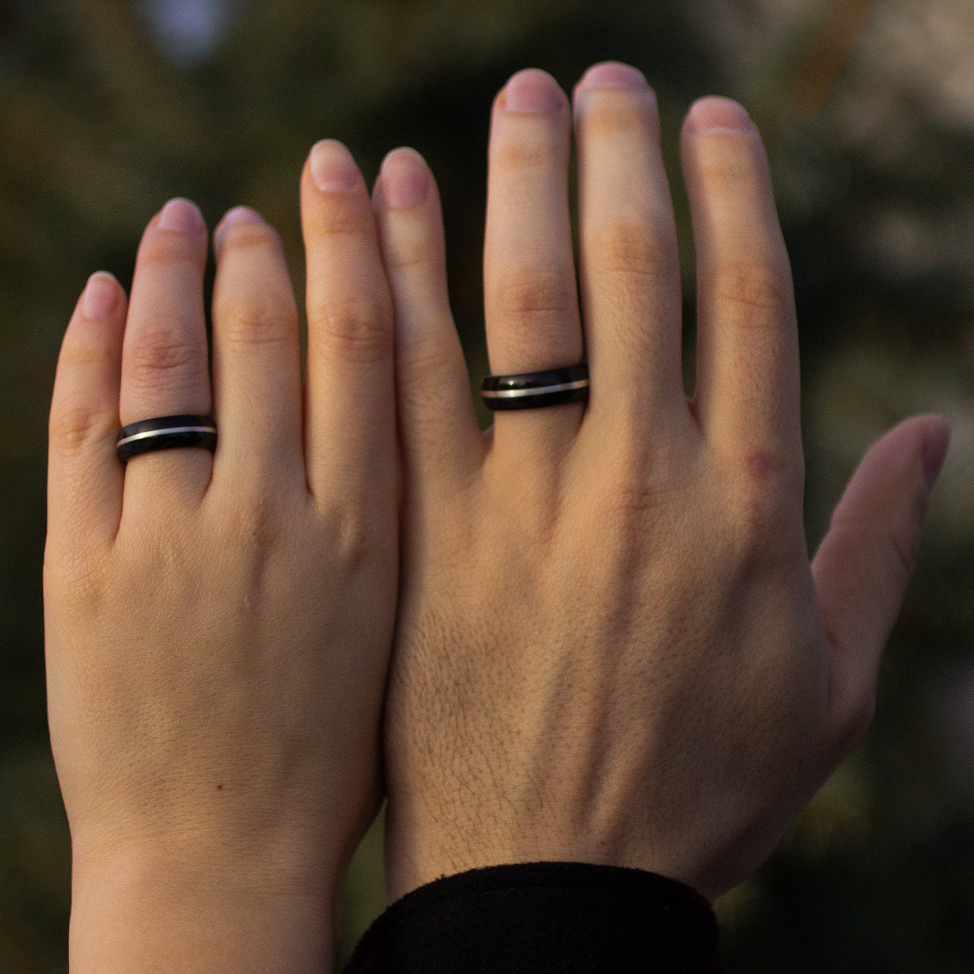 Couple wearing matching Ebony Wood Rings with Silver Inlay by Andrwood, perfect as commitment rings or wood wedding bands.