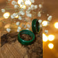 Pair of green-stained hornbeam rings on bark, styled with delicate white flowers and warm fairy lights.