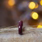 Purpleheart ring standing beside dried wheat stalk, warm ambient background creating cozy mood.