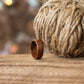 Makore ring placed beside rustic jute twine, styled on wood with soft bokeh in the background.